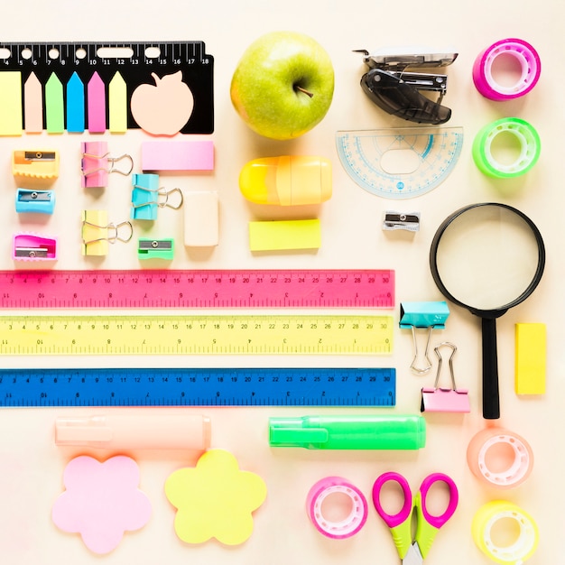 Colorful school supplies on light pink background