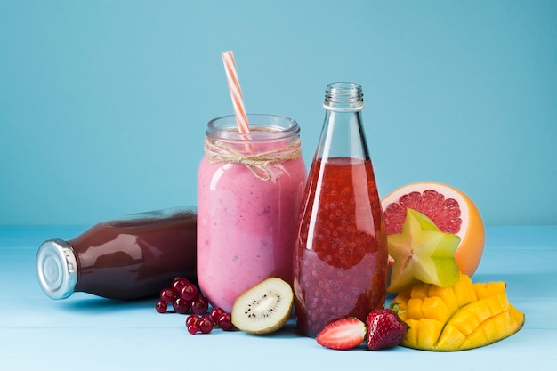 Colorful smoothie bottles and fruit