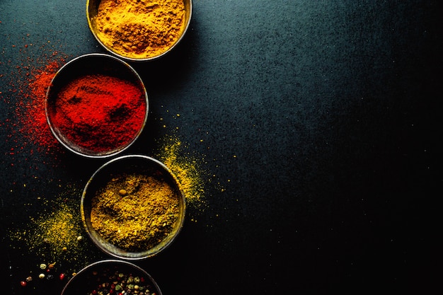 Free photo colorful spices on dark table, copyspace