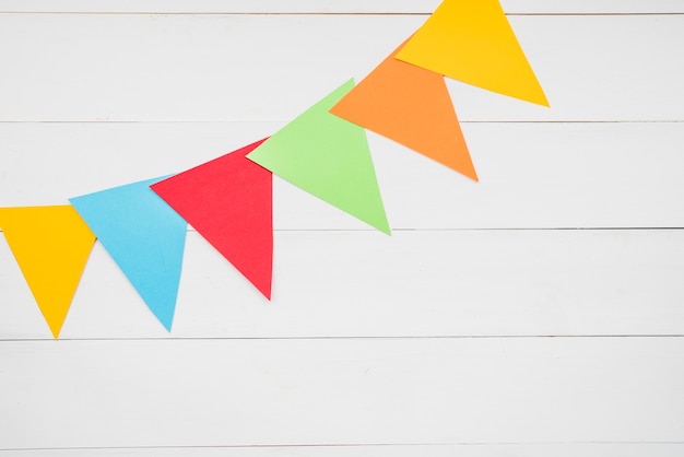 Colorful triangular bunting on white wooden plank