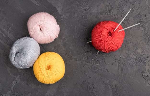 Free photo colorful wool yarn on slate background