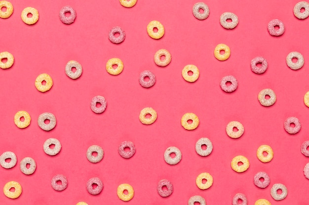 Colourful cereal fruit loops on pink background