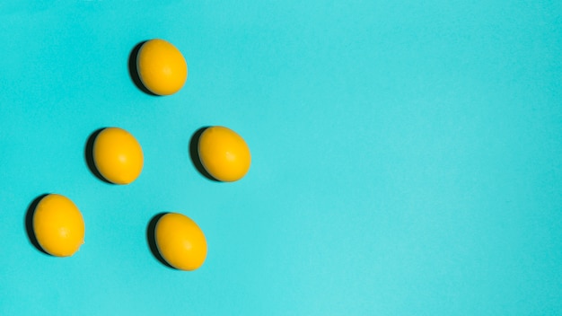 Free photo colourful easter eggs scattered on blue table