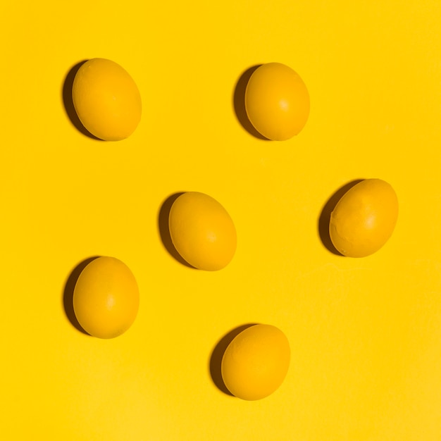 Free Photo colourful easter eggs scattered on yellow table