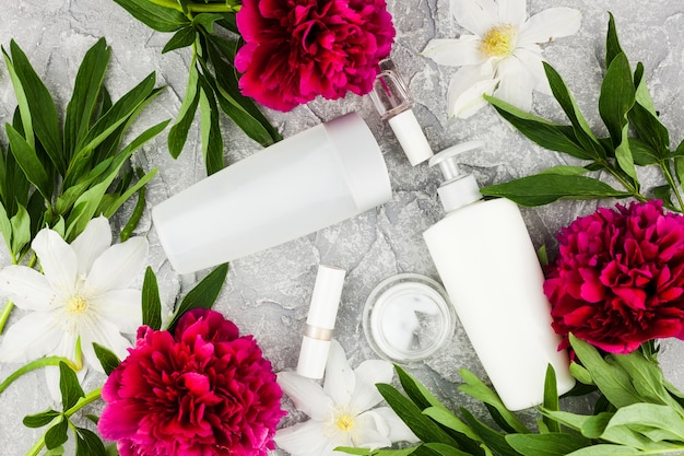 Colourful flowers and cosmetic bottles composition