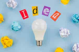 Free photo colourful idea word lettering and real light bulb