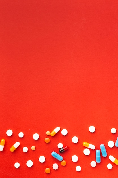 Colourful medical pills and red copy space background