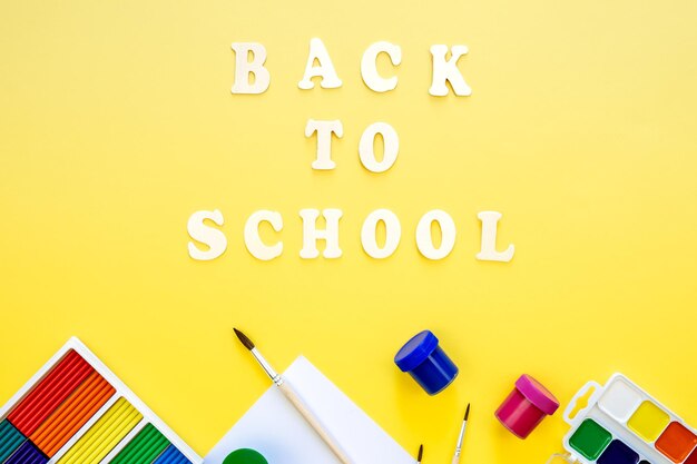 Free photo colourful school supplies on a yellow background back to school concept top view