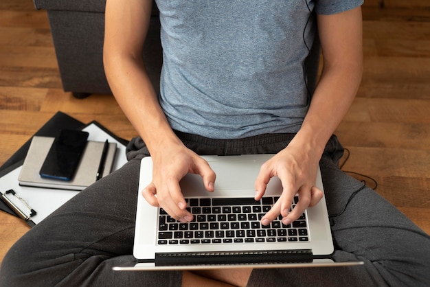 Free photo comfortable man in quarantine at home using laptop to work