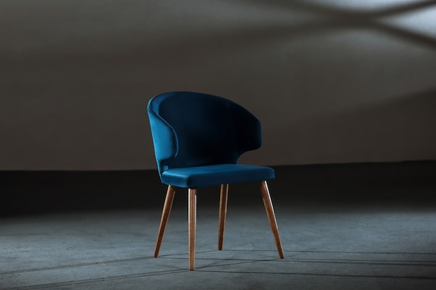 Free Photo comfy blue wing chair in a studio with gray walls