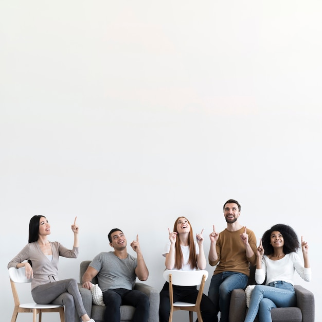 Community of young people with fingers pointing up