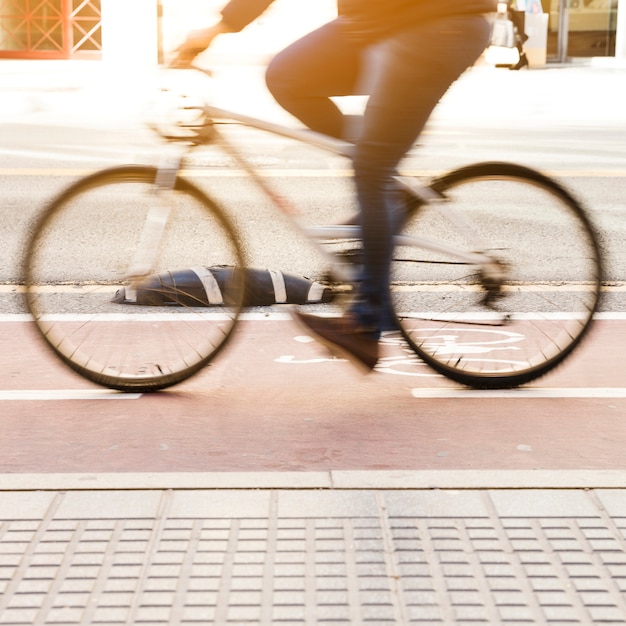 Free photo commuter riding a bicycle on a city cycle lane