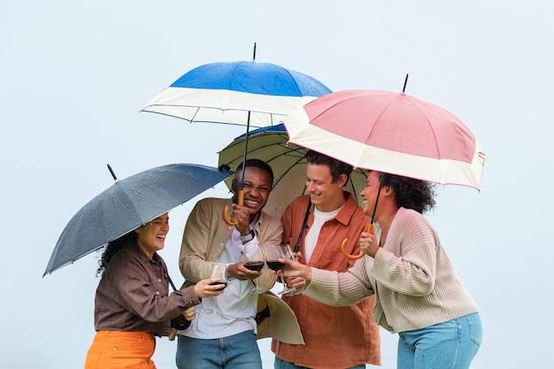 Companions drinking wine under umbrellas during outdoor party