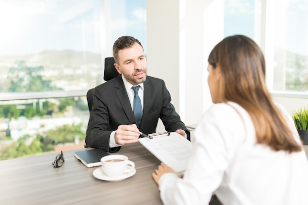 Company director explaining contract terms to new employee in office