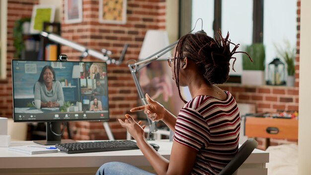 Company employee attending videocall business meeting on computer with webcam, talking to colleagues about remote work. Using online videoconference and remote teleconference call to chat.