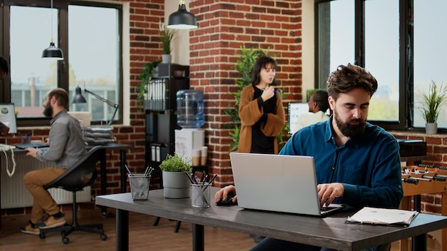 Free photo company employee working on business report with laptop, networking research information and data to plan presentation. office worker sending email with project charts and graphs.