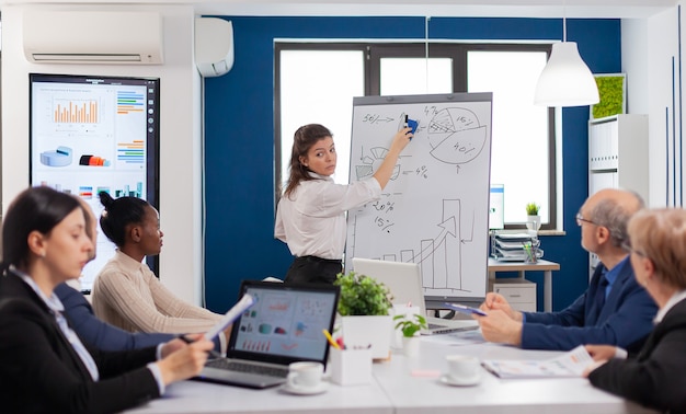 Free photo company head standing in front of audience diverse staff members making presentation