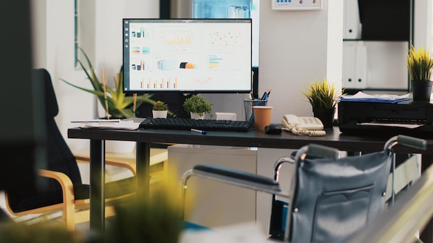 Free photo company workspace with nobody in and marketing pie charts on computer monitors