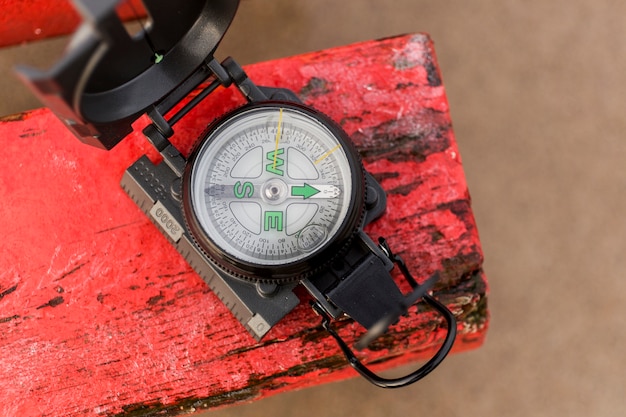 Free photo compass on red piece of wood