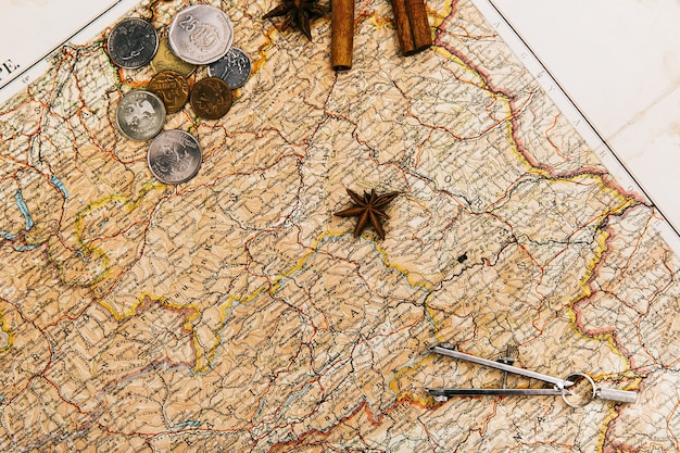 Compasses, spices, envelope lie on old yellow map