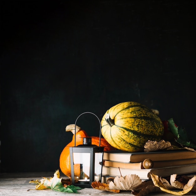 Composed books and pumpkins on black