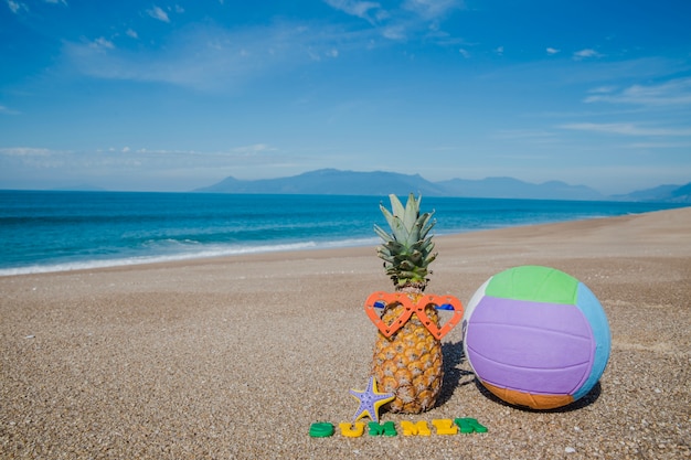 Composed fruit and ball on beach