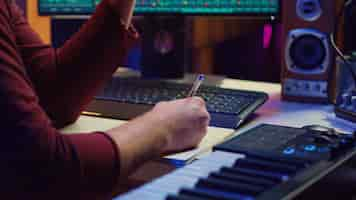 Free photo composer developing an original track in his home studio