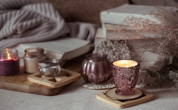 Composition of beautiful vintage candlesticks with burning candles on a blurred background.