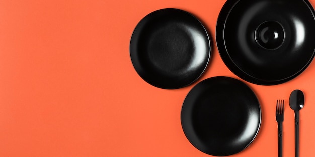 Composition of different sized plates on orange background with copy space