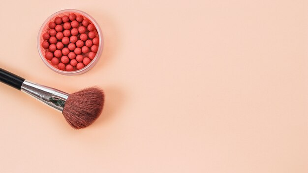 Composition from makeup brush and rouge on light background