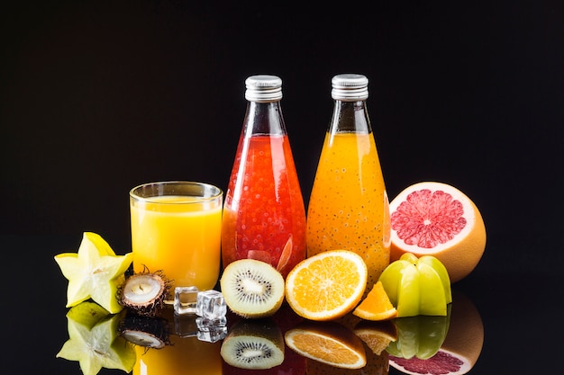 Free Photo composition of fruit and juices on black background