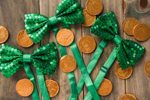 Free photo composition of golden coins and bow ties on wooden board