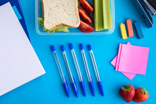 Composition of lunchbox and stationery on table