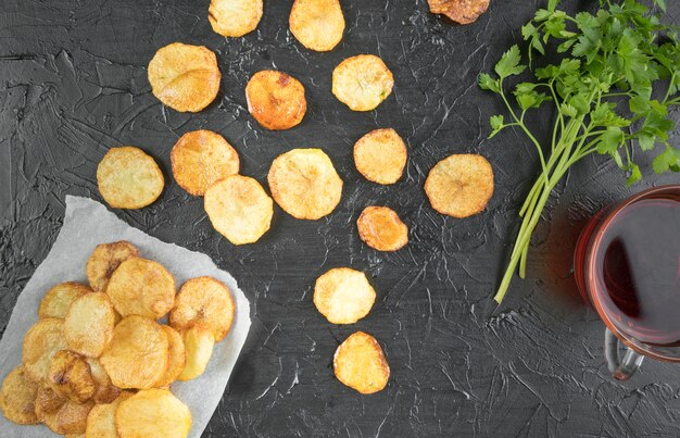 Composition of potato chips on black table