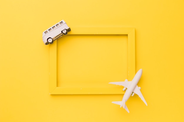 Composition of toy airplane and bus on yellow frame