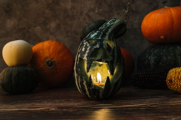 Composition with carved green gourd and lit candle