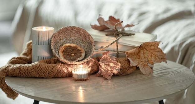 Composition with details of autumn decor on the table in the interior of the room.