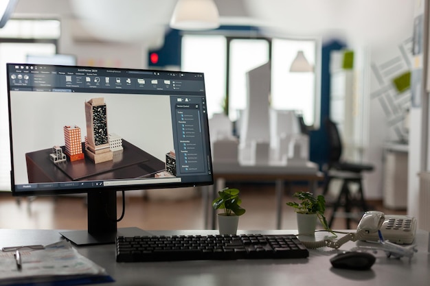 Free photo computer display with 3d render software of architectural building complex in architect modern office. desktop screen on desk showing urban planning architecture construction plans.