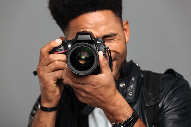 Free photo concentrated afro american man taking photo on digital camera