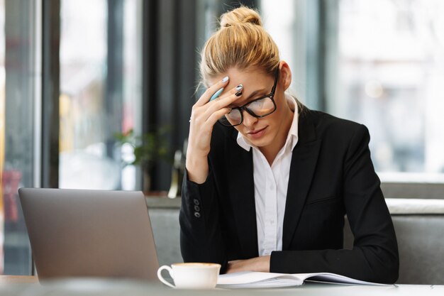 Concentrated business woman writing notes in notebook.