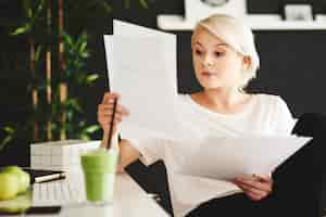 Free photo concentrated businesswoman comparing documents at office