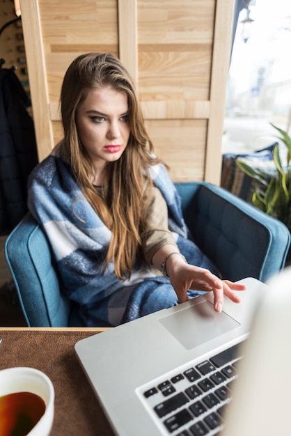 Free photo concentrated girl looking at her laptop screen