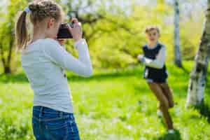 Free photo concentrated girl using her camera outdoors