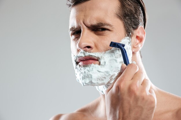 Concentrated man has a shave