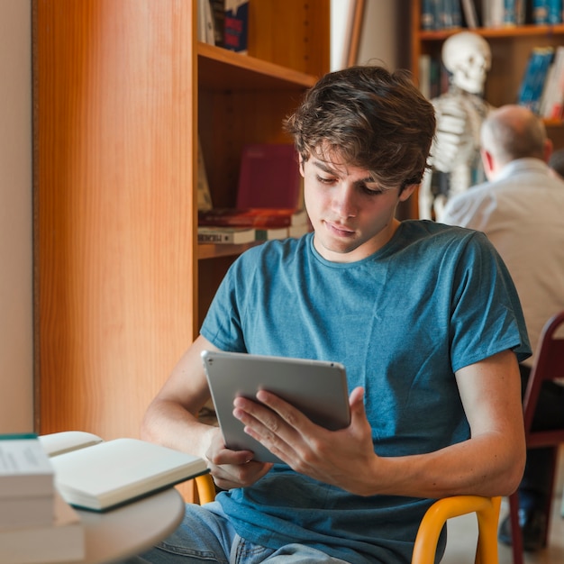 Concentrated man holding tablet in hands