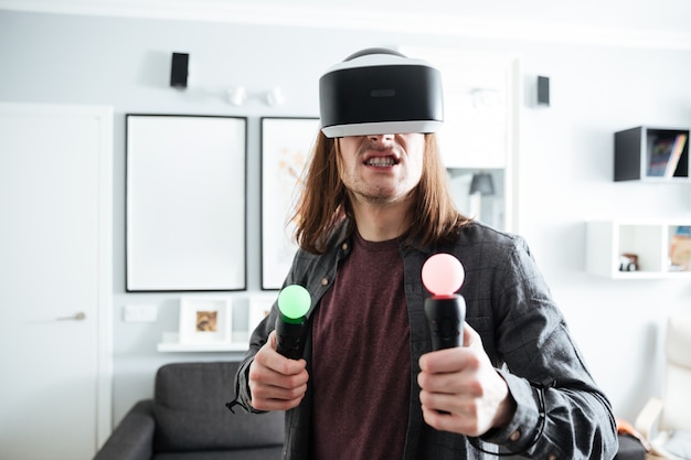 Free photo concentrated man sitting at home indoors play games