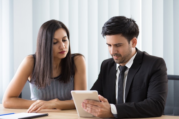 Concentrated multi-ethnic colleagues viewing online report