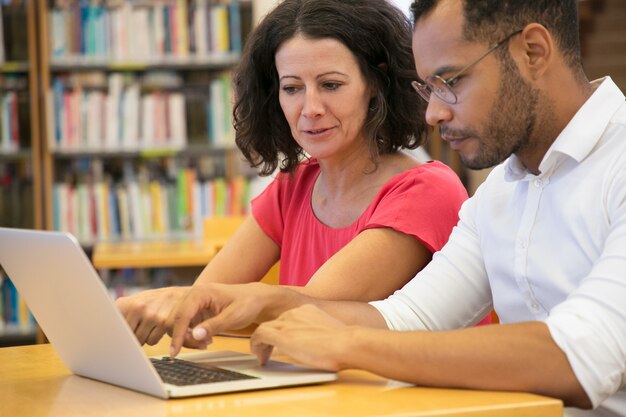 Concentrated people studying with laptop together