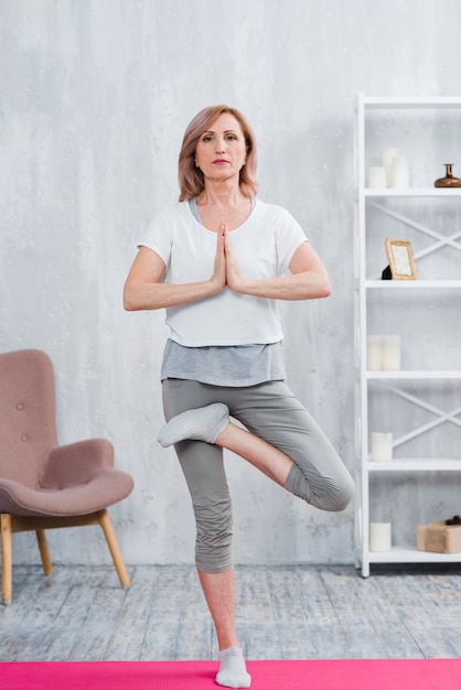 Concentrated senior woman working out indoors