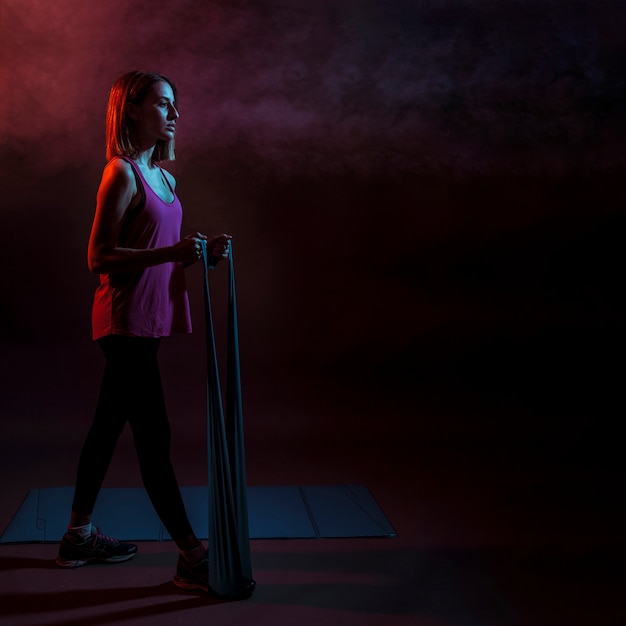 Concentrated woman stretching with elastic band